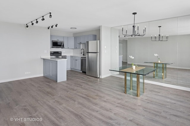 655 W Irving Park Rd Unit 2608, Chicago, IL 60613 - kitchen with stainless steel appliances, a chandelier, gray cabinetry, and light wood finished floors