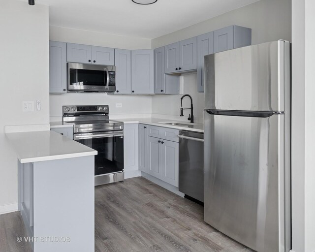 655 W Irving Park Rd Unit 2608, Chicago, IL 60613 - kitchen with appliances with stainless steel finishes, a peninsula, light wood-style flooring, and light countertops