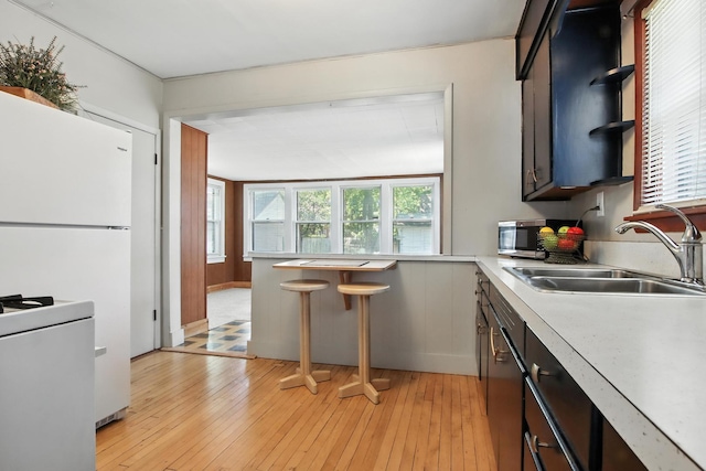 907 W Grove Ave, Waukegan, IL 60085 - kitchen featuring light countertops, light wood finished floors, range, freestanding refrigerator, and open shelves