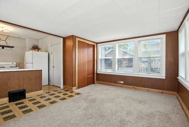 907 W Grove Ave, Waukegan, IL 60085 - kitchen featuring white appliances, brown cabinets, wooden walls, light countertops, and light colored carpet