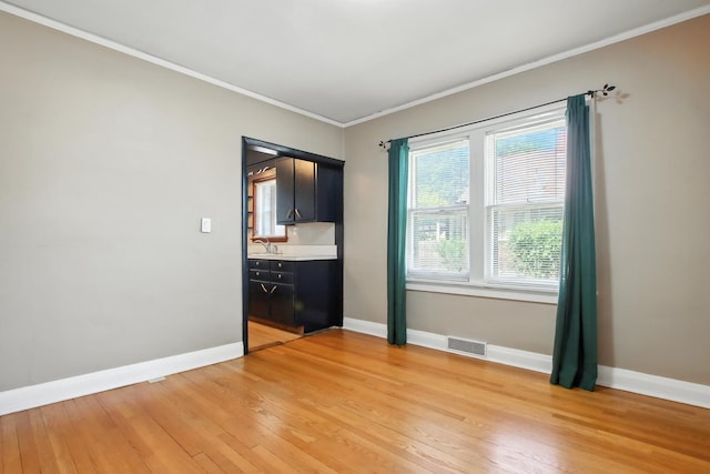 907 W Grove Ave, Waukegan, IL 60085 - spare room with light wood-style floors and crown molding