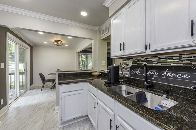 38515 N Forest Ave, Spring Grove, IL 60081 - kitchen with backsplash, crown molding, white cabinetry, a peninsula, and healthy amount of natural light
