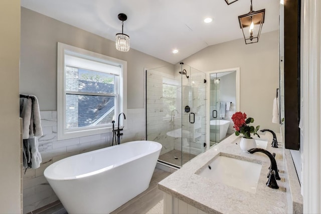 1832 N 73rd Ct, Elmwood Park, IL 60707 - bathroom featuring tile walls, a freestanding tub, a shower stall, double vanity, and vaulted ceiling