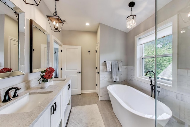 1832 N 73rd Ct, Elmwood Park, IL 60707 - full bath featuring a freestanding tub, double vanity, a chandelier, tile walls, and recessed lighting