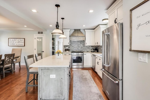 1832 N 73rd Ct, Elmwood Park, IL 60707 - kitchen with stainless steel appliances, premium range hood, white cabinets, a kitchen bar, and tasteful backsplash
