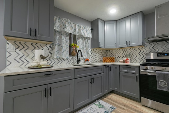 2431 Sandy Hollow Rd, Rockford, IL 61109 - kitchen featuring stainless steel gas range, gray cabinetry, backsplash, and light wood-style floors