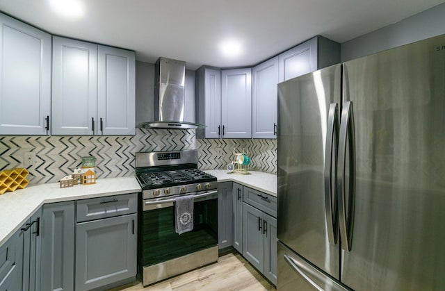 2431 Sandy Hollow Rd, Rockford, IL 61109 - kitchen featuring stainless steel appliances, wall chimney exhaust hood, gray cabinetry, decorative backsplash, and light wood-style floors