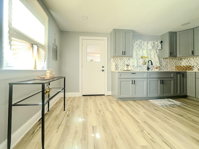 2431 Sandy Hollow Rd, Rockford, IL 61109 - kitchen featuring decorative backsplash, light wood-type flooring, gray cabinetry, and light countertops