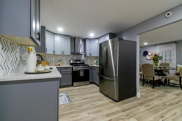 2431 Sandy Hollow Rd, Rockford, IL 61109 - kitchen featuring appliances with stainless steel finishes, wall chimney exhaust hood, light wood-style floors, light countertops, and recessed lighting
