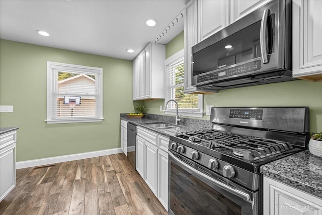 218 N Berteau Ave, Bartlett, IL 60103 - kitchen featuring appliances with stainless steel finishes, white cabinetry, wood finished floors, dark stone counters, and recessed lighting