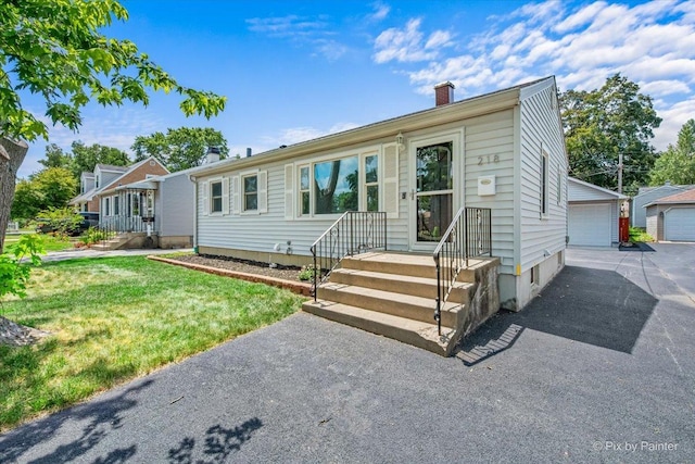218 N Berteau Ave, Bartlett, IL 60103 - ranch-style house with a chimney, a detached garage, a front yard, and an outbuilding