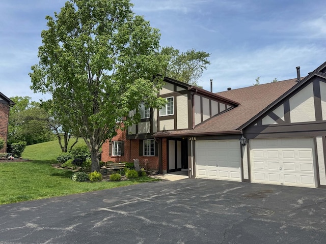 258 Brookside Ln Unit B, Willowbrook, IL 60527 - tudor house featuring asphalt driveway, an attached garage, a front yard, brick siding, and a shingled roof