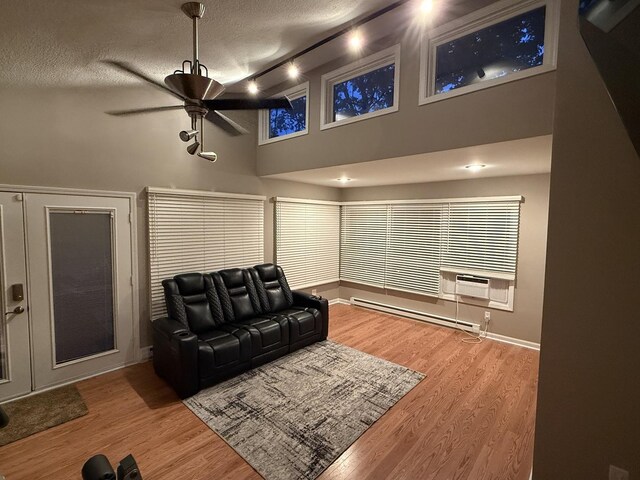 127 S Front St, Hennepin, IL 61327 - living room with a baseboard radiator, a textured ceiling, wood finished floors, a ceiling fan, and high vaulted ceiling