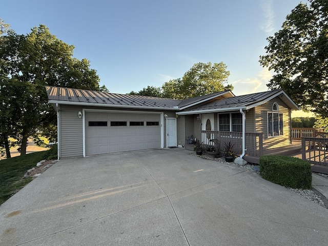 127 S Front St, Hennepin, IL 61327 - single story home with a metal roof, an attached garage, concrete driveway, and a porch