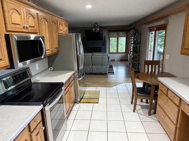 127 S Front St, Hennepin, IL 61327 - kitchen with stainless steel appliances, a fireplace, brown cabinets, and light countertops