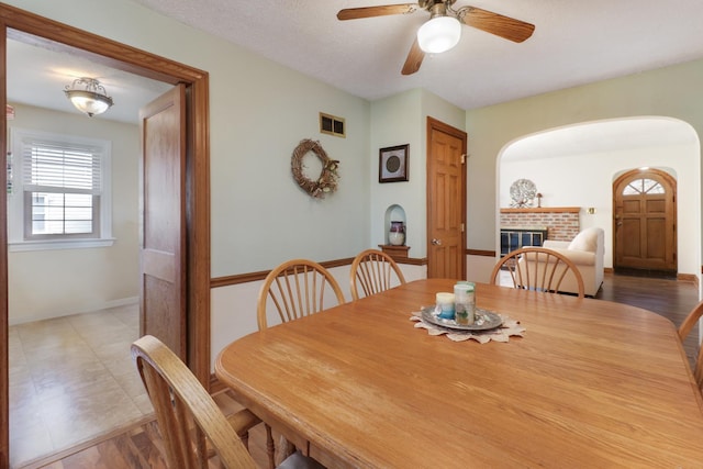 1211 Hovey Ave, Normal, IL 61761 - dining space with a fireplace, arched walkways, and a ceiling fan