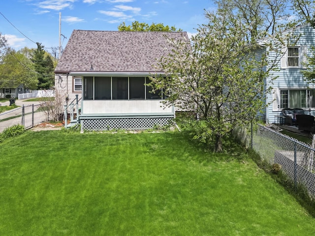 1211 Hovey Ave, Normal, IL 61761 - back of house featuring a fenced backyard, a sunroom, and a shingled roof