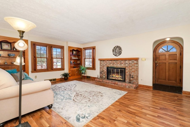 1211 Hovey Ave, Normal, IL 61761 - living area with wood finished floors, a textured ceiling, healthy amount of natural light, and a fireplace