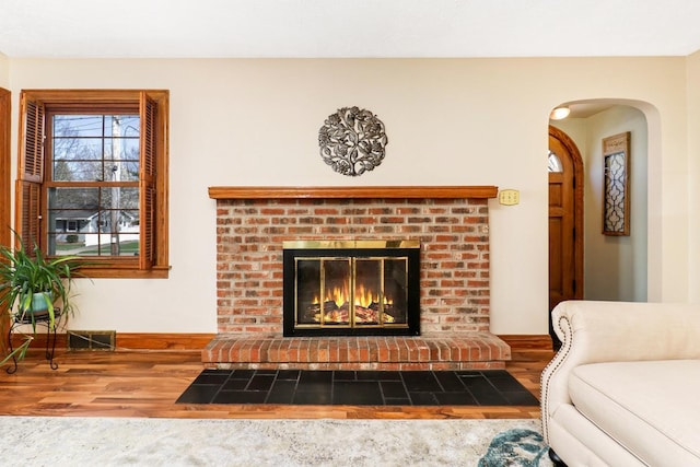 1211 Hovey Ave, Normal, IL 61761 - living room with wood finished floors, arched walkways, and a brick fireplace