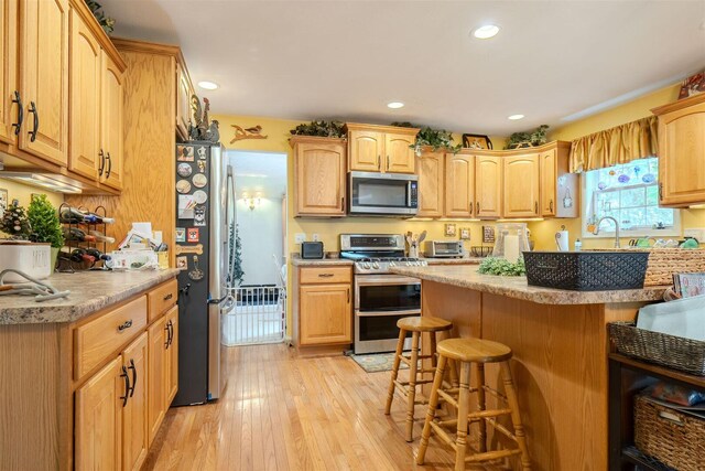 2321 Hayden Way, Normal, IL 61761 - kitchen with appliances with stainless steel finishes, a breakfast bar, light wood finished floors, recessed lighting, and light countertops