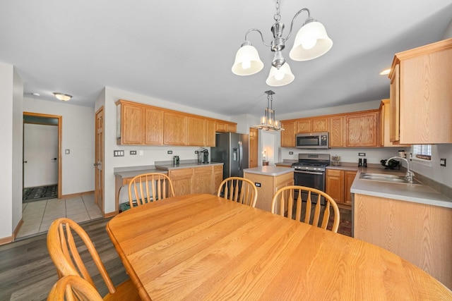 940 Hyte St, Plano, IL 60545 - kitchen with stainless steel appliances, a chandelier, a kitchen island, light wood-style floors, and light countertops