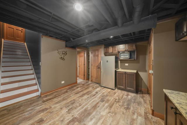 940 Hyte St, Plano, IL 60545 - finished below grade area with freestanding refrigerator, light wood-style flooring, and stairs