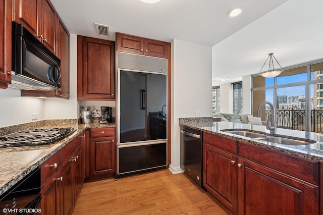 21 E Huron St Unit 1407, Chicago, IL 60611 - kitchen featuring stainless steel appliances, light wood-type flooring, dark stone counters, and reddish brown cabinets