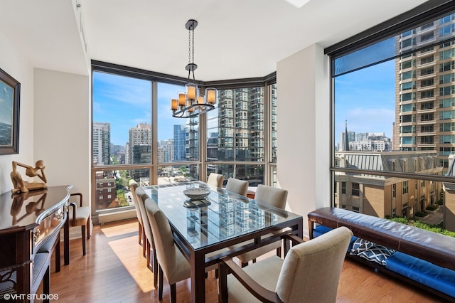 21 E Huron St Unit 1407, Chicago, IL 60611 - dining space featuring a view of skyline, expansive windows, a chandelier, and wood finished floors