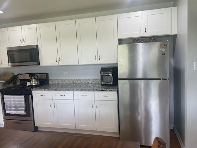 7401 W 113th Pl, Worth, IL 60482 - kitchen featuring stainless steel appliances, white cabinetry, stone counters, dark wood-type flooring, and recessed lighting