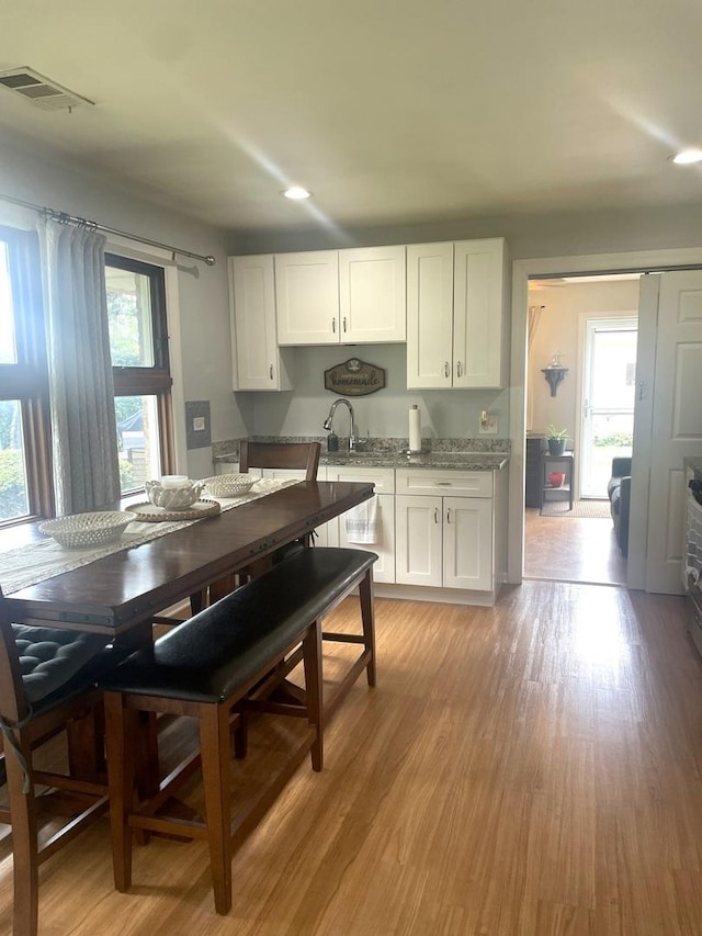 7401 W 113th Pl, Worth, IL 60482 - kitchen with white cabinetry, recessed lighting, light wood-style flooring, and light stone counters