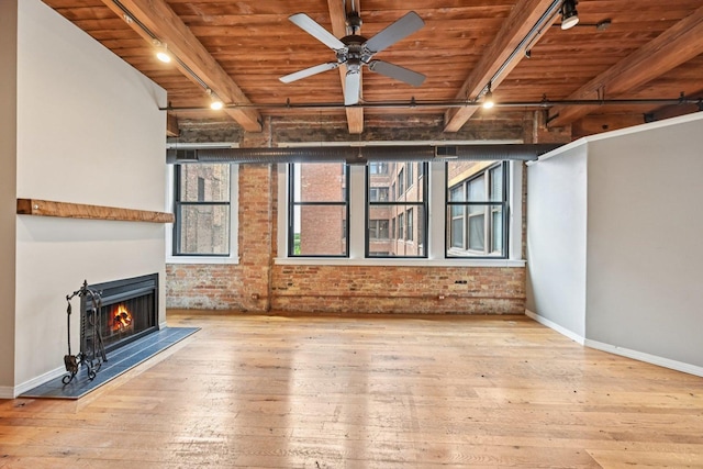 913 W Van Buren St Unit 5H, Chicago, IL 60607 - unfurnished living room with a wooden ceiling with exposed beams, hardwood / wood-style floors, brick wall, rail lighting, and a lit fireplace