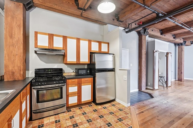 913 W Van Buren St Unit 5H, Chicago, IL 60607 - kitchen with appliances with stainless steel finishes, under cabinet range hood, dark countertops, a wood ceiling with exposed beams, and glass insert cabinets