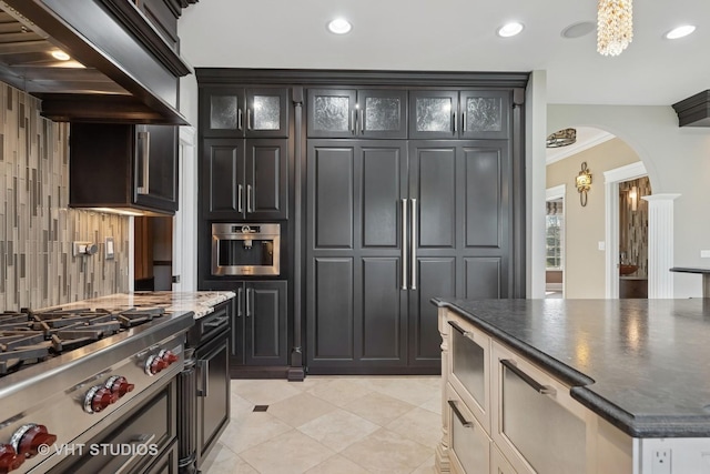 22 Westlake Dr, South Barrington, IL 60010 - kitchen featuring arched walkways, stainless steel gas stovetop, range hood, glass insert cabinets, and recessed lighting