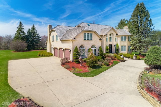 22 Westlake Dr, South Barrington, IL 60010 - french country style house featuring a chimney, an attached garage, driveway, a high end roof, and a front lawn
