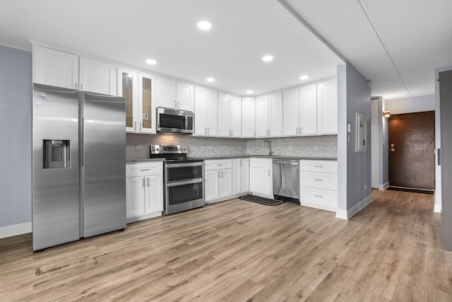 850 Des Plaines Ave Unit 405, Forest Park, IL 60130 - kitchen featuring stainless steel appliances, white cabinetry, light wood-style floors, tasteful backsplash, and glass insert cabinets
