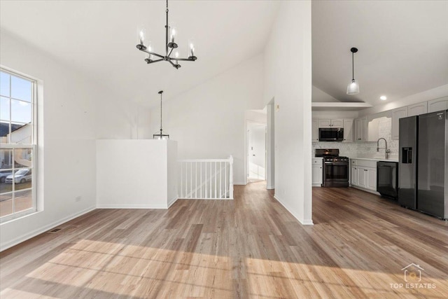 17437 Yakima Dr, Lockport, IL 60441 - unfurnished living room featuring a chandelier, light wood-type flooring, and high vaulted ceiling