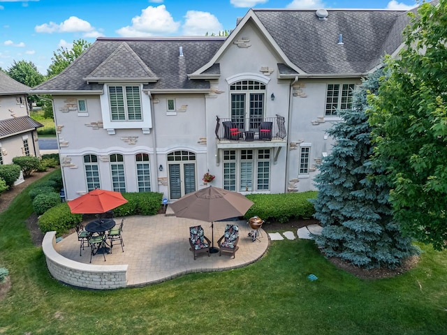8 Willowcrest Dr, Oak Brook, IL 60523 - rear view of property featuring a balcony, stucco siding, a lawn, a patio, and roof with shingles