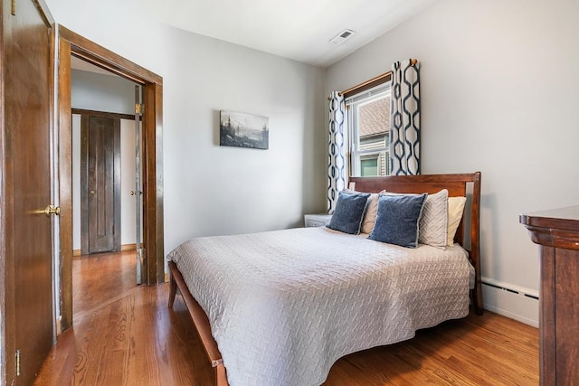 5240 W Eddy St, Chicago, IL 60641 - bedroom featuring a baseboard heating unit and wood finished floors