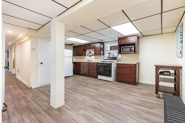 5240 W Eddy St, Chicago, IL 60641 - kitchen featuring white appliances, light wood-style floors, light countertops, a paneled ceiling, and dark brown cabinets