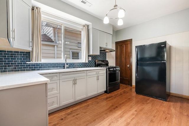 5240 W Eddy St, Chicago, IL 60641 - kitchen featuring freestanding refrigerator, gas stove, light wood-style floors, and light countertops