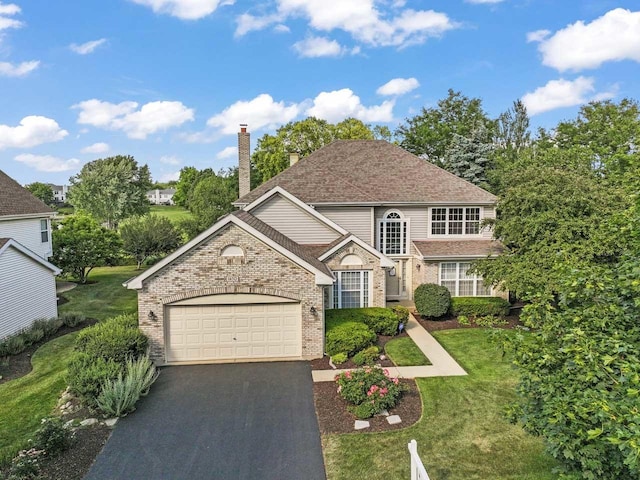 1450 Anvil Ct, Bartlett, IL 60103 - view of front facade featuring brick siding, a garage, driveway, a chimney, and a front lawn