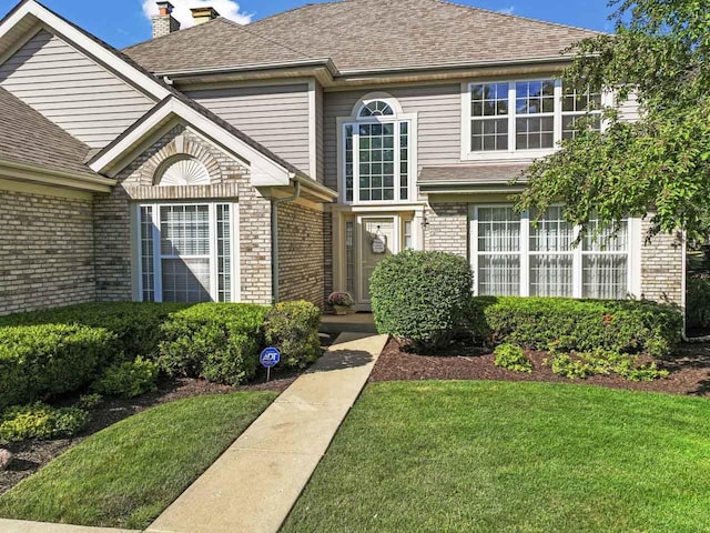 1450 Anvil Ct, Bartlett, IL 60103 - view of front facade featuring brick siding, a front lawn, a chimney, and roof with shingles