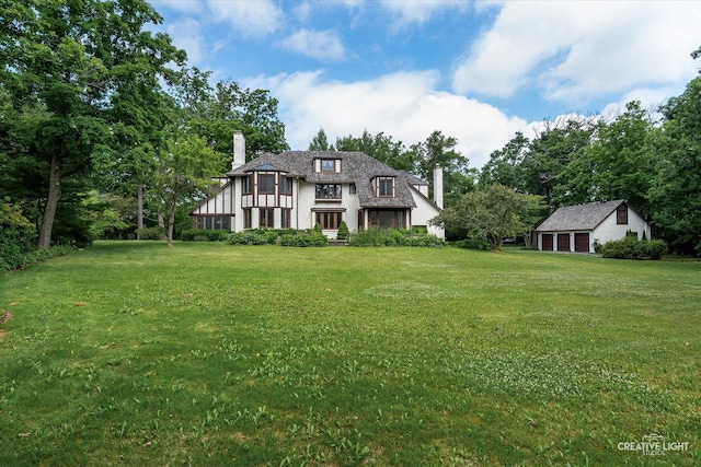 595 Crab Tree Ln, Lake Forest, IL 60045 - tudor house featuring a chimney, a front lawn, an outbuilding, and stucco siding