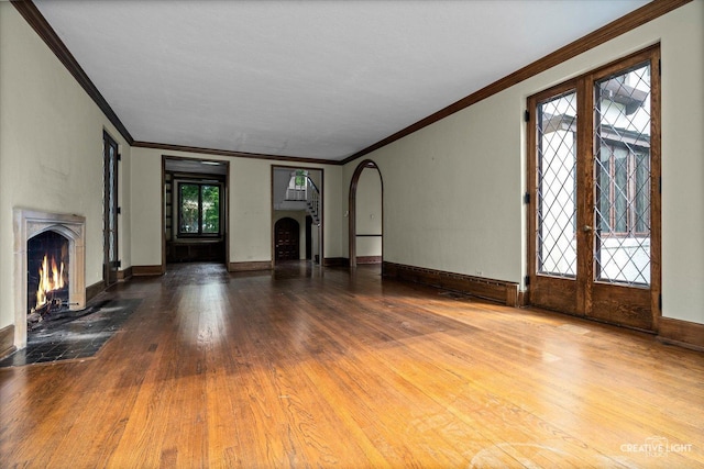 595 Crab Tree Ln, Lake Forest, IL 60045 - unfurnished living room featuring ornamental molding, a fireplace, french doors, wood finished floors, and arched walkways