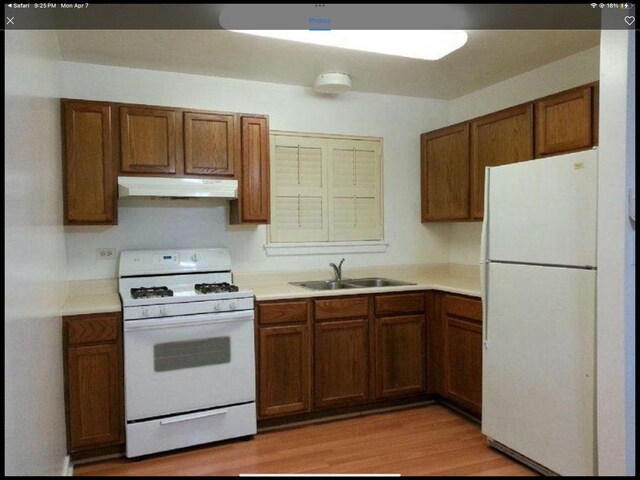 6419 S Kenwood Ave, Chicago, IL 60637 - kitchen featuring white appliances, under cabinet range hood, light countertops, brown cabinets, and light wood-type flooring