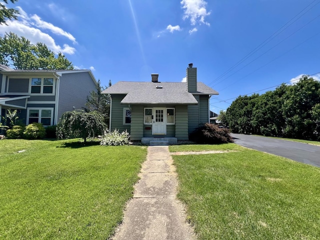 1713 Glenn Park Dr, Champaign, IL 61821 - bungalow-style home featuring a chimney, a front lawn, and a shingled roof