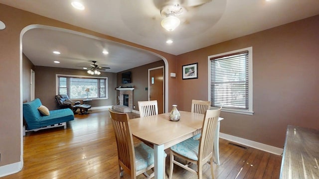1713 Glenn Park Dr, Champaign, IL 61821 - dining room featuring arched walkways, ceiling fan, hardwood / wood-style flooring, a brick fireplace, and recessed lighting