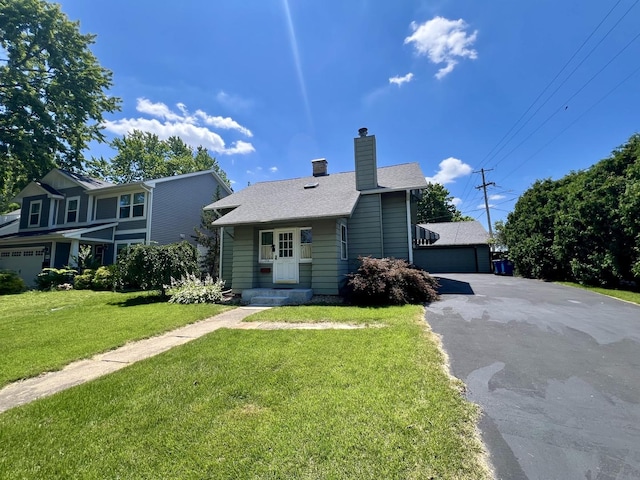 1713 Glenn Park Dr, Champaign, IL 61821 - view of front facade with a chimney, a front yard, roof with shingles, and a detached garage