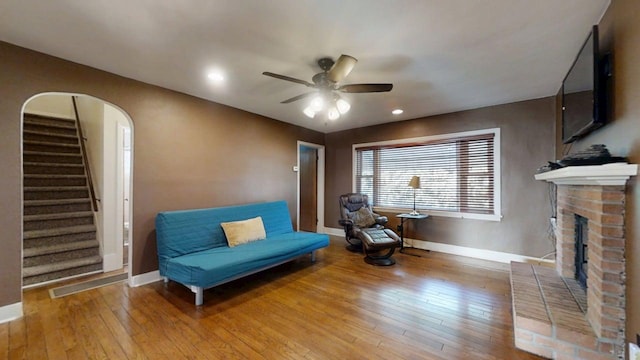 1713 Glenn Park Dr, Champaign, IL 61821 - living area featuring light wood finished floors, ceiling fan, a brick fireplace, stairs, and recessed lighting
