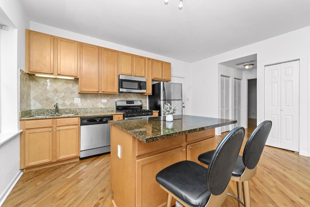 2414 W Bryn Mawr Ave Unit 1W, Chicago, IL 60659 - kitchen with appliances with stainless steel finishes, light wood-style flooring, a breakfast bar, and tasteful backsplash